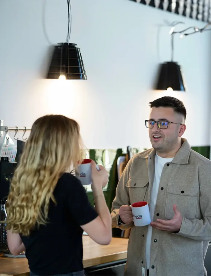 Zwei Mitglieder des FFMEDIA-Teams bei einer Tasse Kaffee im Büro in Magdeburg